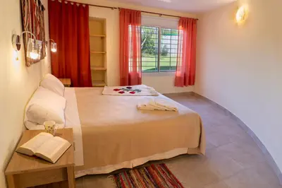 a bedroom with a bed and a window with red curtains at Cabaña para relajarse con vista panorámica in Villa General Belgrano