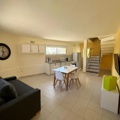 a kitchen and a living room with a table and chairs at Dorrego Departamentos in Villa Dolores
