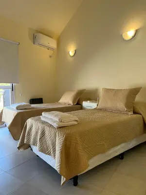 two beds sitting in a room with at Dorrego Departamentos in Villa Dolores