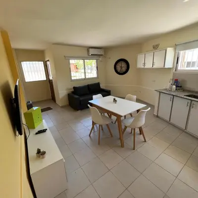 a kitchen and living room with a table and chairs at Dorrego Departamentos in Villa Dolores