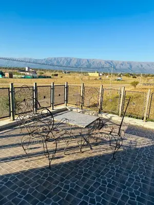 a metal bench sitting on a patio with a view of a field at Casa Valle del colibrí in Cañada La Negra