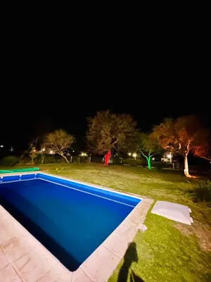 a blue swimming pool in a field at night at Casa Valle del colibrí in Cañada La Negra