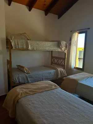 a bedroom with two bunk beds and a window at Cabañas Casa Flor Yacanto in Villa Yacanto