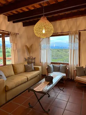 a living room with a couch and a table at Cabañas Casa Flor Yacanto in Villa Yacanto