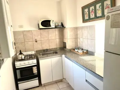 a small kitchen with a stove and a microwave at Departamento en Alberdi in Cordoba