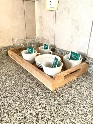 a wooden tray with bowls and plates on a counter at Departamento en Alberdi in Cordoba