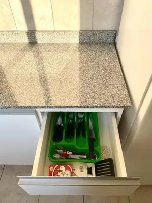 a kitchen drawer with a green tray of utensils at Departamento en Alberdi in Cordoba