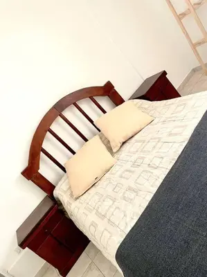 a bed with a wooden headboard and a pillow on it at Departamento en Alberdi in Cordoba