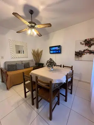 a dining room with a table and a couch at CASA Q Cba Zona Norte Kempes Aeropuerto Shopping cochera asador patio full equipada confortable in Cordoba