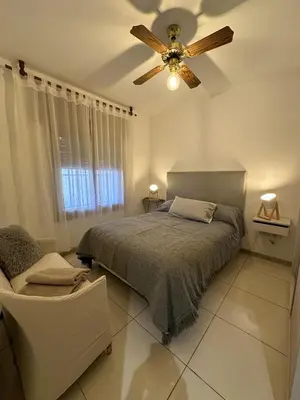 a bedroom with a bed and a ceiling fan at CASA Q Cba Zona Norte Kempes Aeropuerto Shopping cochera asador patio full equipada confortable in Cordoba