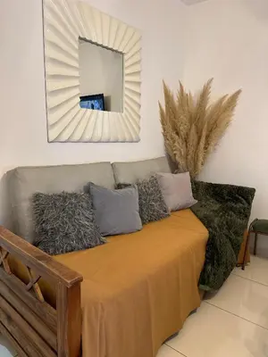 a mirror on the wall above a couch with pillows at CASA Q Cba Zona Norte Kempes Aeropuerto Shopping cochera asador patio full equipada confortable in Cordoba