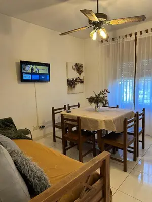 a dining room with a table and chairs and a tv at CASA Q Cba Zona Norte Kempes Aeropuerto Shopping cochera asador patio full equipada confortable in Cordoba