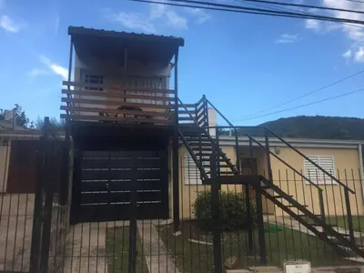 a building with a staircase in front of a house at Depto temporario carlos paz in Villa Carlos Paz