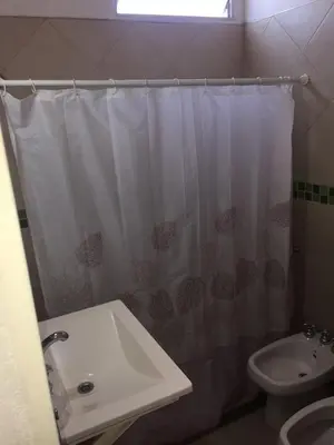 a bathroom with a white shower curtain and a sink at Depto temporario carlos paz in Villa Carlos Paz