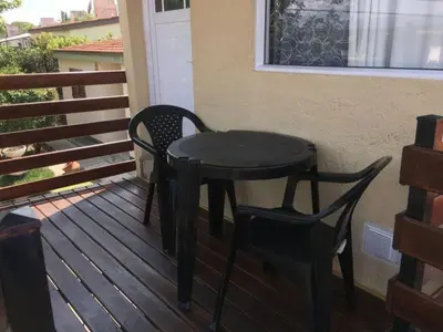 a black table and two chairs on a porch at Depto temporario carlos paz in Villa Carlos Paz