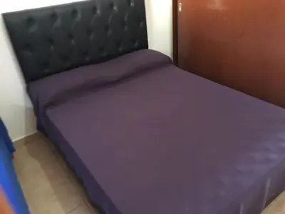 a bed in a room with purple sheets on it at Depto temporario carlos paz in Villa Carlos Paz