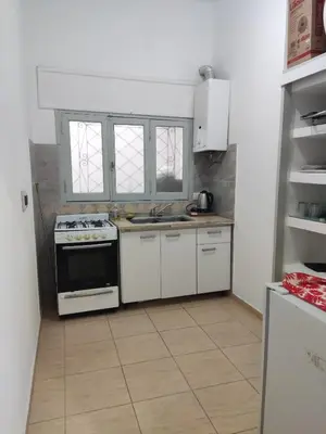 a kitchen with white cabinets and a stove at Velez Dpto in Río Tercero