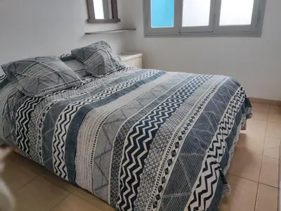 a bed with a black and white comforter in a bedroom at Velez Dpto in Río Tercero