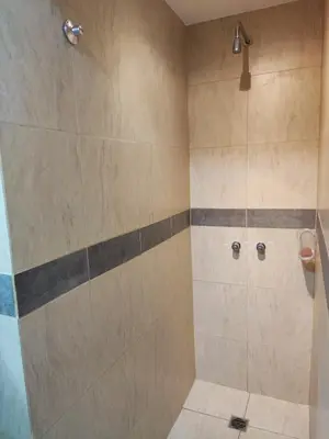 a bathroom with a shower with beige and gray tiles at Velez Dpto in Río Tercero