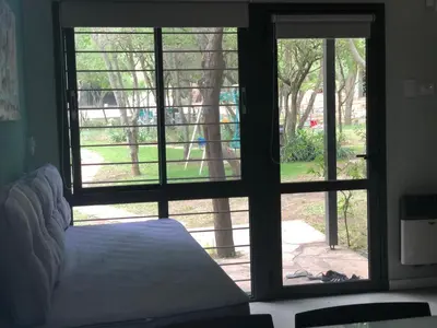 a bedroom with a bed looking out of a window at Cabañas Apart Margaridas in Merlo