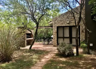 a stone house with a patio and a table at Cabañas Apart Margaridas in Merlo