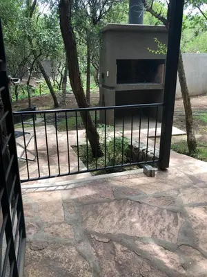 a grill sitting on a patio next to a fence at Cabañas Apart Margaridas in Merlo