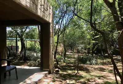 an open door to a garden with a bench at Cabañas Apart Margaridas in Merlo