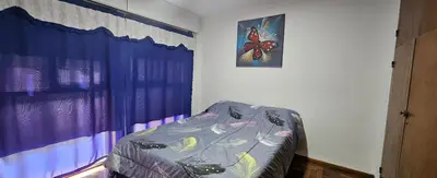 a bedroom with a bed with a butterfly picture on the wall at Departamento -Córdoba Capital- zona Centro in Cordoba