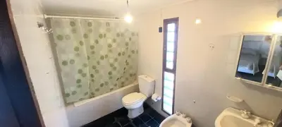 a bathroom with a toilet and two sinks and a window at La Casona in Cordoba