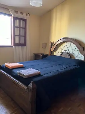 a bedroom with a large wooden bed with blue sheets at Luis marcelo in Alta Gracia