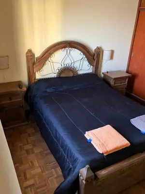 a bedroom with a bed with a blue blanket on it at Luis marcelo in Alta Gracia