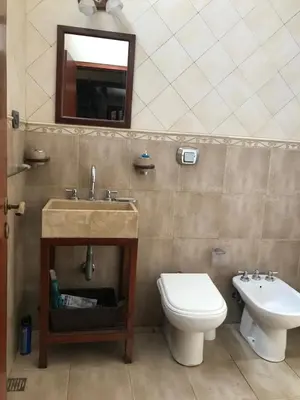 a bathroom with a sink and a toilet and a mirror at Luis marcelo in Alta Gracia
