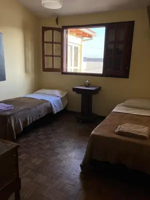 a room with two beds and a sink and a window at Luis marcelo in Alta Gracia