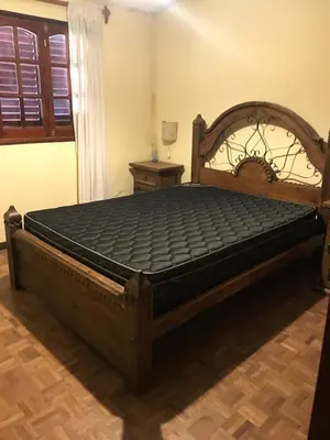 a bed in a room with a wooden bed frame at Luis marcelo in Alta Gracia