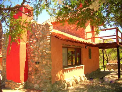 a stone building with a window and a tree at Cabañas en Piedras Maia in Merlo