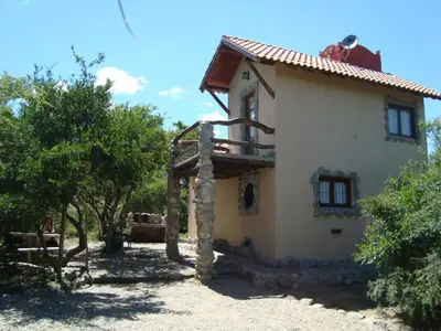 a house in the middle of a yard with trees at Cabañas en Piedras Maia in Merlo