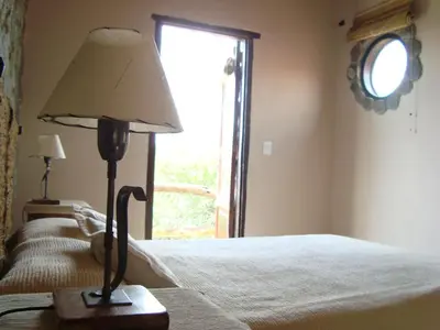 a bedroom with a bed with a lamp and a window at Cabañas en Piedras Maia in Merlo