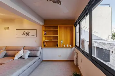 a living room with a couch and a large window at Departamento Centrico en Villa Carlos Paz in Villa Carlos Paz