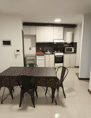 a kitchen with a table and chairs in a room at Sommet I in Villa Carlos Paz
