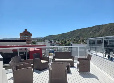 a balcony with chairs and tables on a roof at Sommet I in Villa Carlos Paz