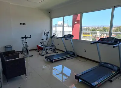 a fitness room with three exercise bikes and a window at Sommet I in Villa Carlos Paz