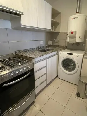 a kitchen with a sink and a washing machine at Balcarce Deluxe in Cordoba