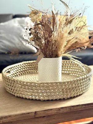 a white basket with dried grass in it on a table at Balcarce Deluxe in Cordoba