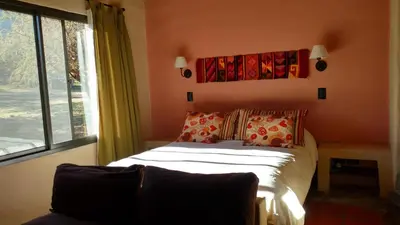 a bedroom with a bed and a large window at Cabañas Chacras del Arroyo Vidal in Carpintería