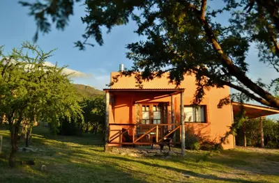 a small house in the middle of a field at Cabañas Chacras del Arroyo Vidal in Carpintería
