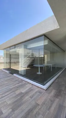 a large glass building with a table and stairs at Carlos Paz-Lake Towers in Villa Carlos Paz