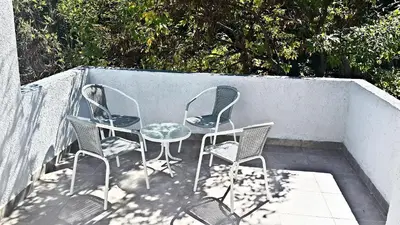 three chairs and a table on a patio at Jazmines Departamentos in Santa Rosa de Calamuchita
