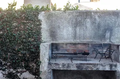 a bench sitting in front of a stone wall at Jazmines Departamentos in Santa Rosa de Calamuchita