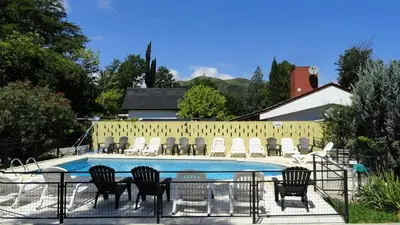 a group of chairs sitting around a swimming pool at Posada Ojo de Agua Villa General Belgrano in Villa General Belgrano
