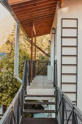 a stairway leading up to a house with a wooden roof at Posada Ojo de Agua Villa General Belgrano in Villa General Belgrano